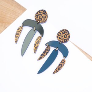 Pendientes articulados con diseño en metacrilato negro y piezas estampadas en animal print sobre fondo blanco